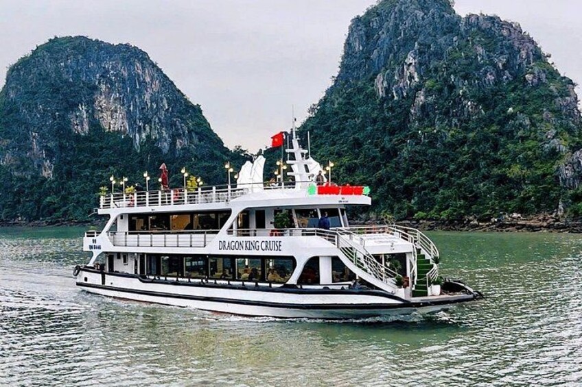 A boat named 'Dragon King Cruise' on water with mountainous landscape in the background. 4