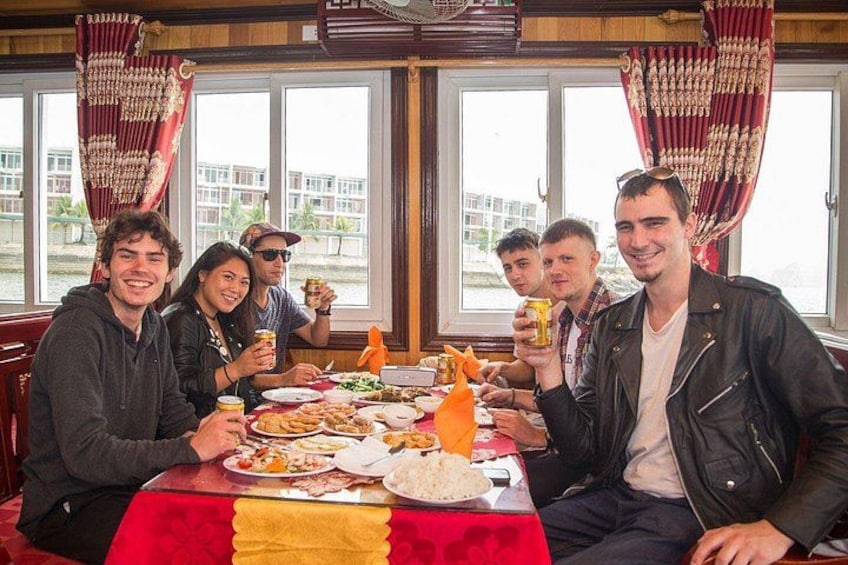 A group of people dining at a table with food and drinks. 4