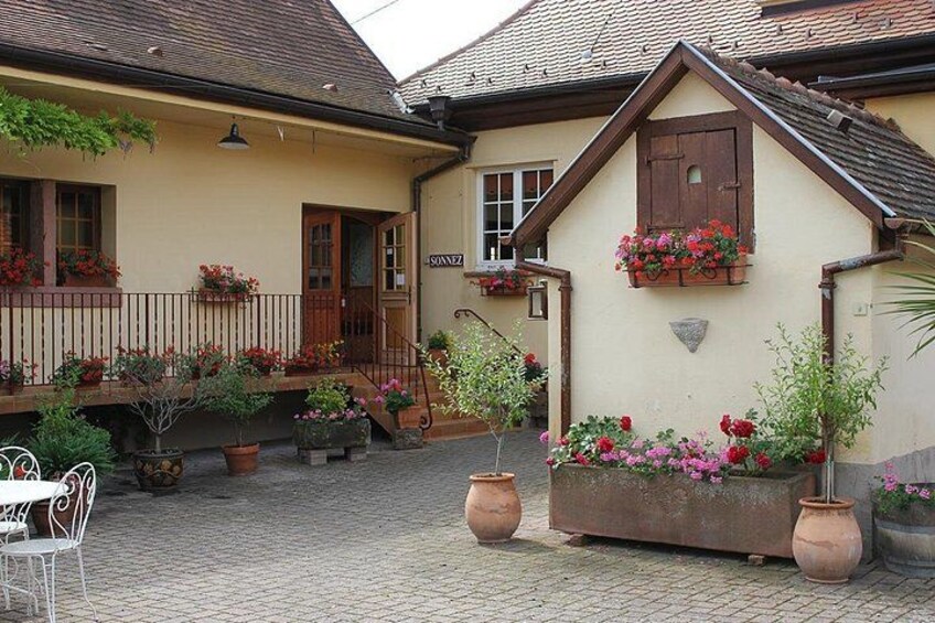 Un edificio europeo tradizionale con tetto in tegole, persiane in legno e balconi fioriti. 1