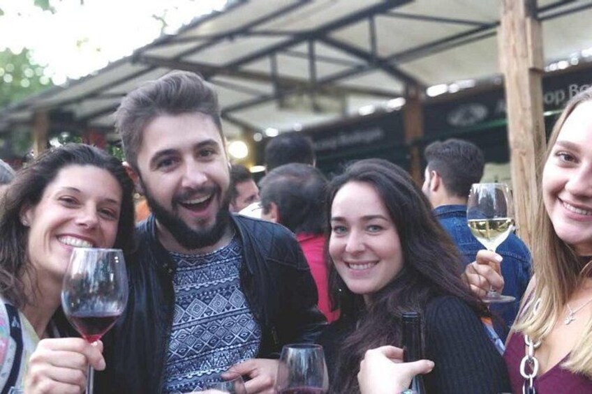 Un groupe de personnes lors d’un événement en plein air, tenant des verres à vin. 5