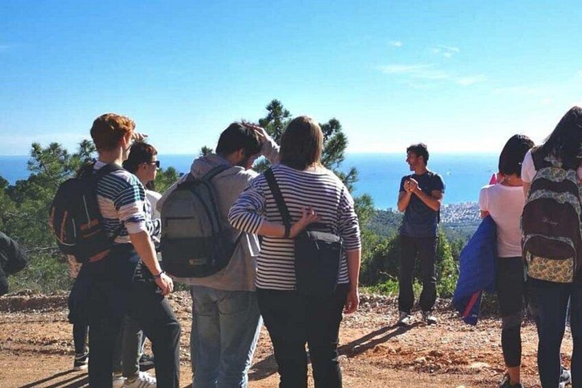 Un groupe de personnes se tient sur une colline, d’où elles dominent un paysage côtier. 4