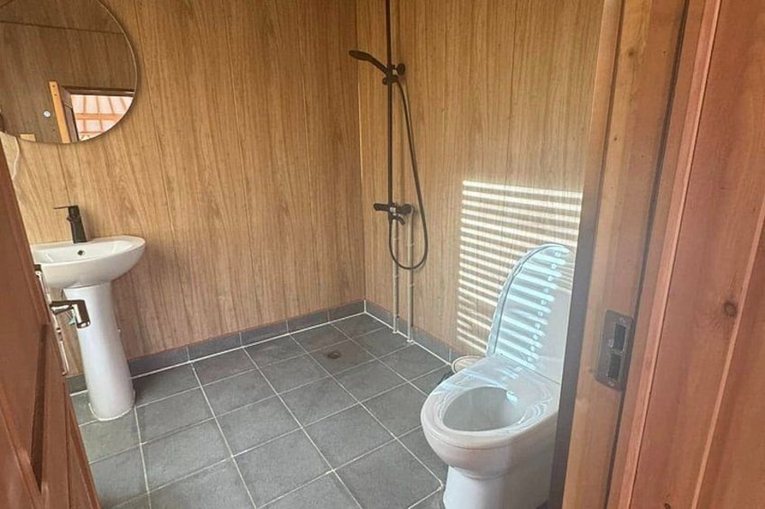 A small bathroom with a toilet, sink, and shower. 2