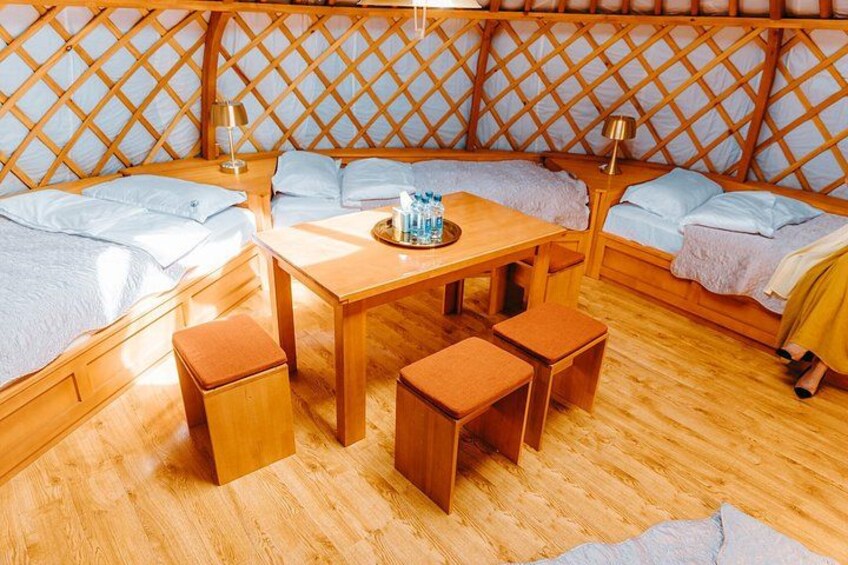 A cozy room with wooden furniture, including a table and benches, and a lattice-patterned wall. 3