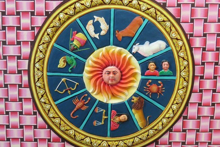 Un mosaico circolare con una figura centrale simile al sole, circondata da diversi simboli di animali e oggetti. 2