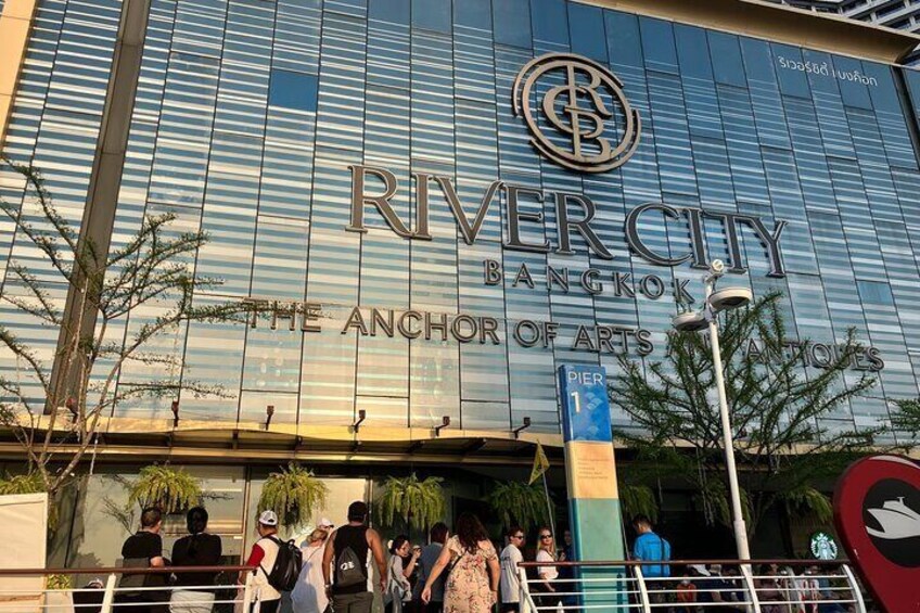 The exterior of Rivercity Bangkok, The Anchor of Arts, with a blue sign indicating Pier 1. 2