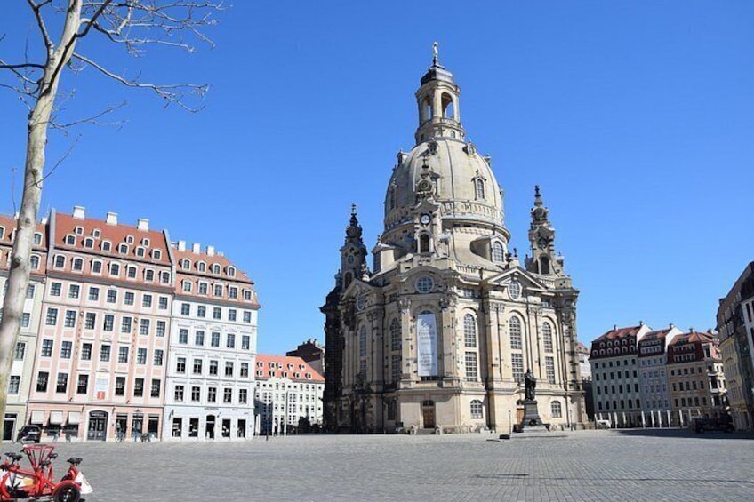 A historic building with a prominent dome and spire, surrounded by modern buildings. 4