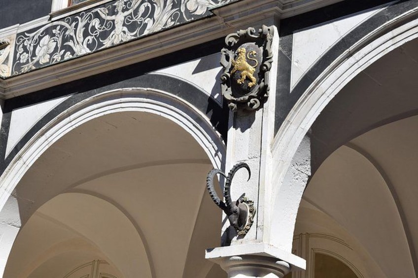 A building with ornate black and gold detailing, including a lion crest and a decorative metalwork. 3