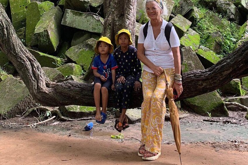 Une personne qui marche avec un enfant, et un autre enfant assis sur une branche d’arbre. 3