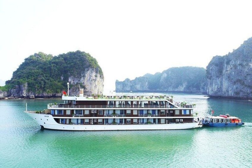 A large river cruise ship with multiple decks, surrounded by rocky cliffs and lush greenery. 3