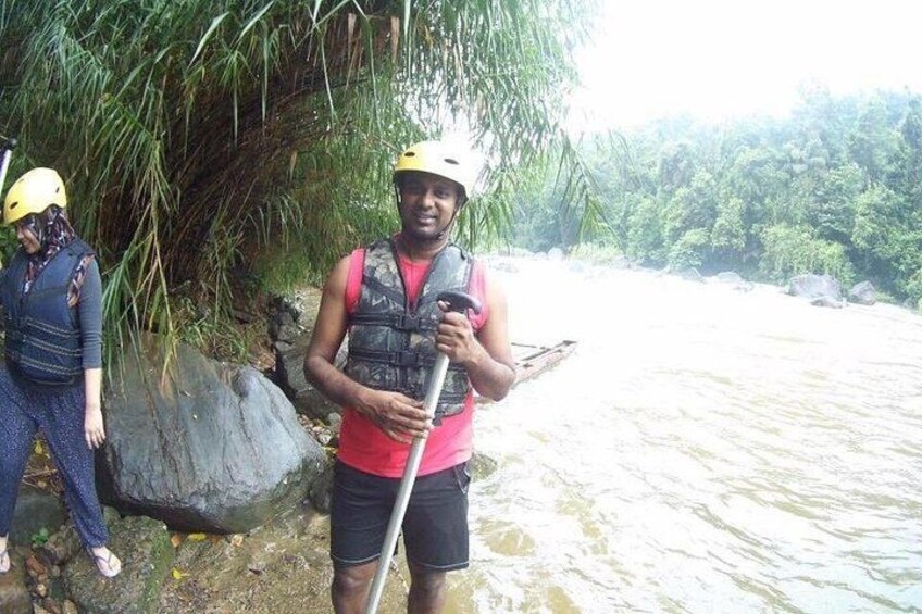 Two people standing by a river, one holding a paddle. 5