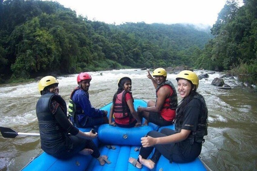 A group of people on a blue raft in a river surrounded by greenery. 4