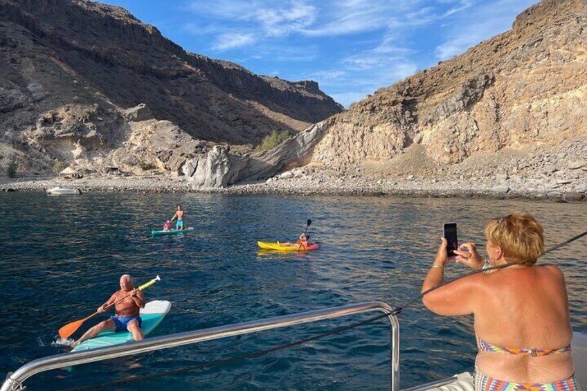 Personas haciendo kayak en un río tranquilo bordeado por acantilados rocosos. 2