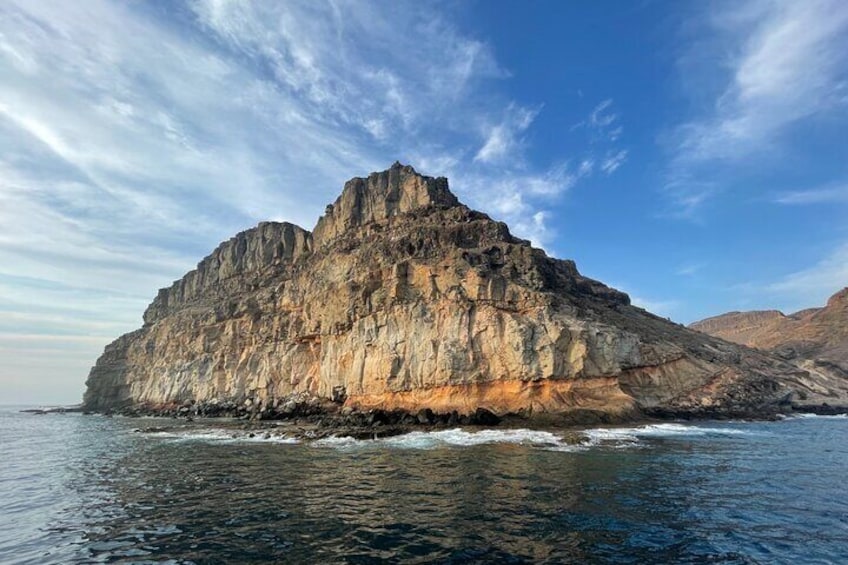 Una isla rocosa grande con acantilados escarpados y un cielo azul despejado. 3