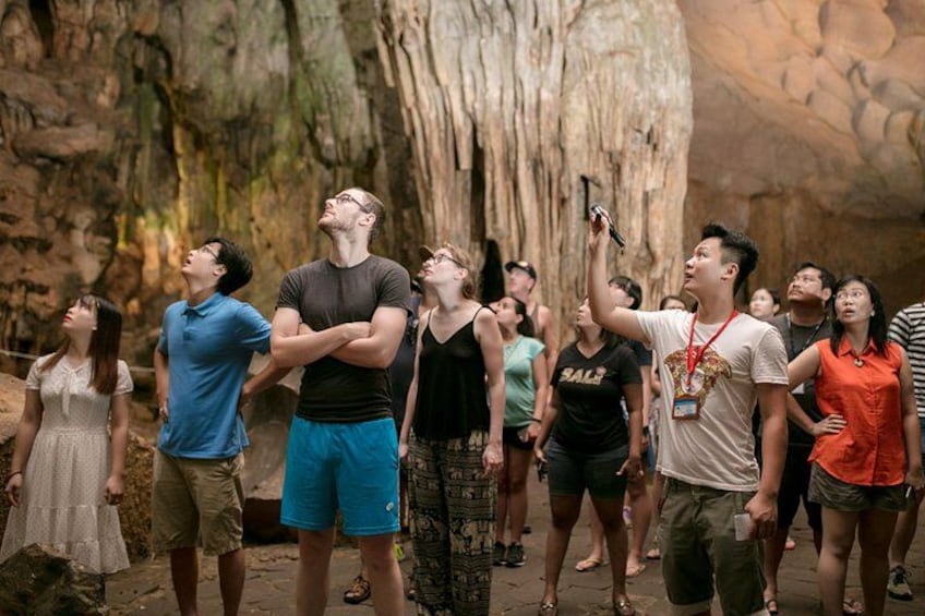 A group of people in a cave-like setting, some taking photos. 4