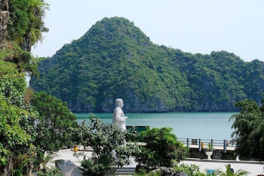 A statue overlooking a body of water with a mountainous backdrop. 3