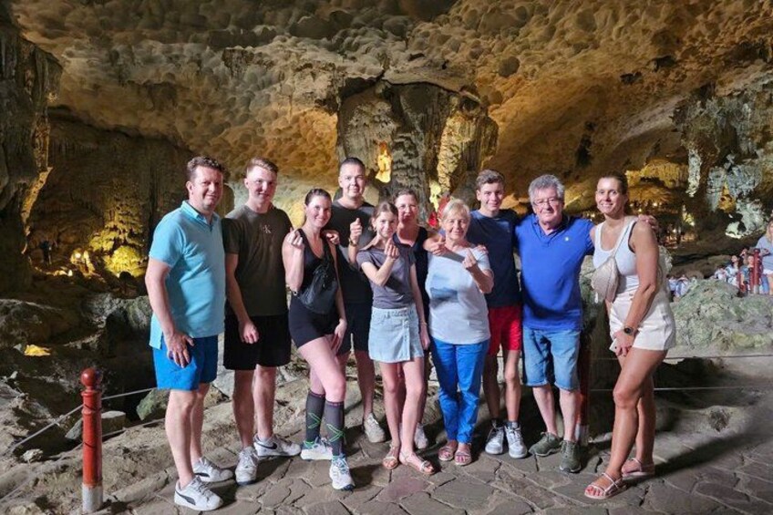 A group of people standing in a cave with stalactites and stalagmites. 5