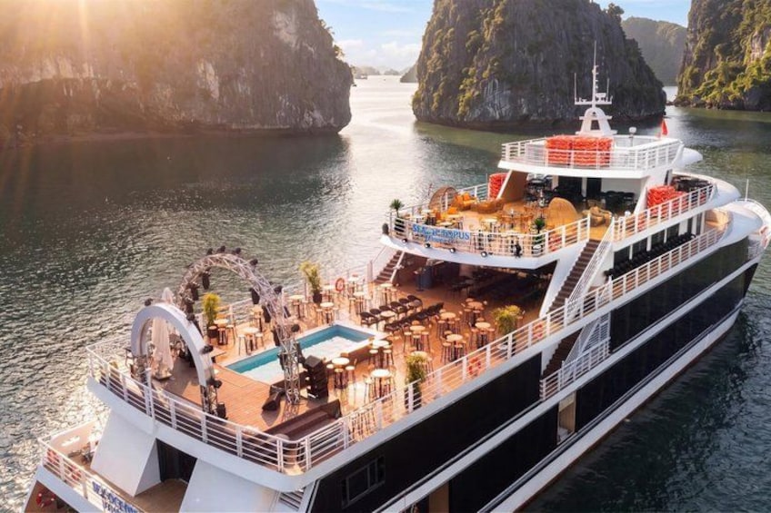 A cruise ship with a swimming pool, outdoor seating, and a deck area. 1