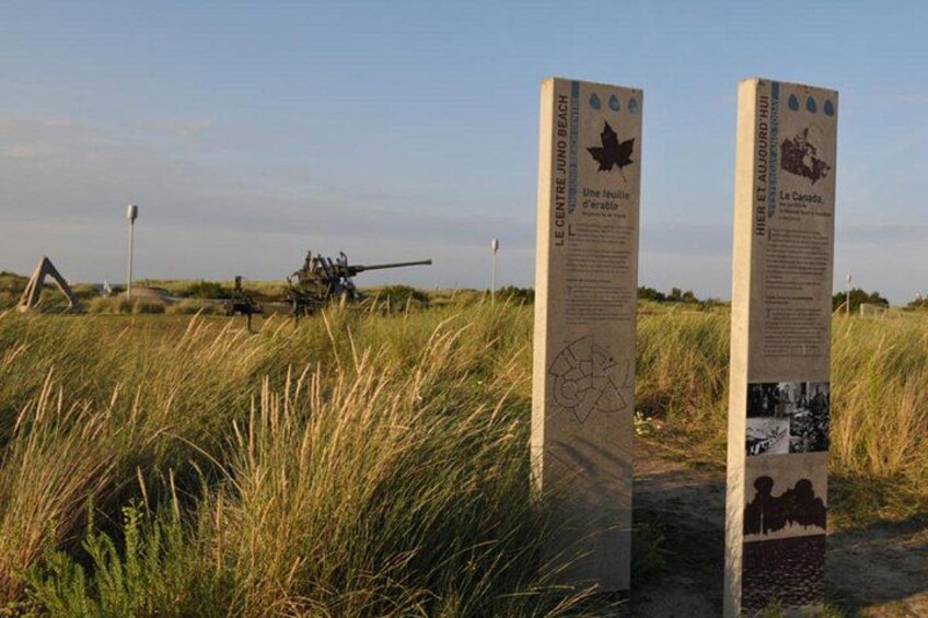 Två informationsskyltar med text och ett militärfordon i bakgrunden. 4