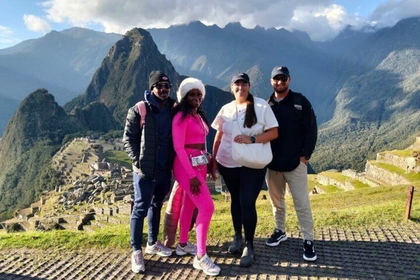A group of people standing on a path with a mountainous landscape in the background. 1
