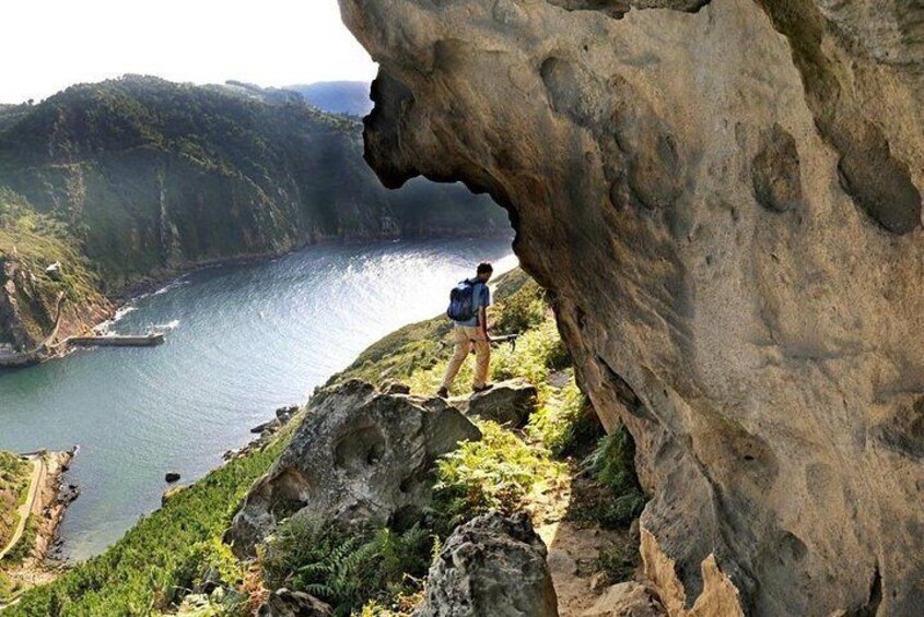 A person hiking near a coastal cliff with a view of the ocean. 1