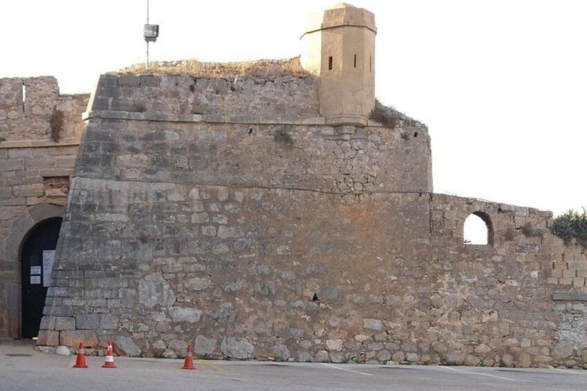 Una pared de piedra con una torre de vigilancia y una entrada arqueada. 2