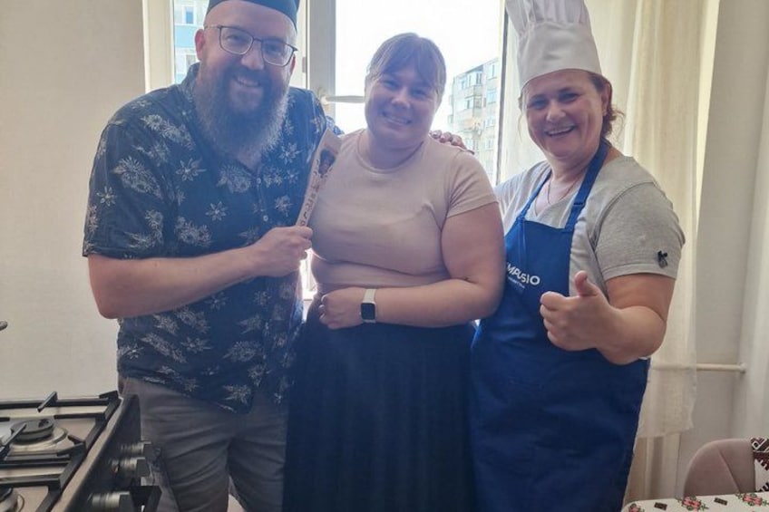 Trois personnes dans une cuisine, dont une porte un chapeau de chef. 4