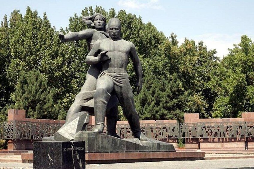 A statue of two figures, one larger and one smaller, with a plaque in front. 3