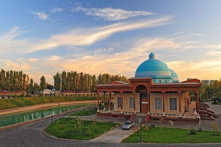 A building with a blue dome, a paved road, and a water body. 1