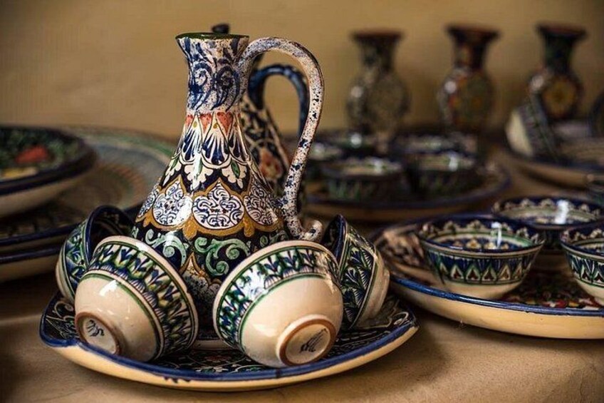 A collection of intricately designed ceramic items, including a pitcher and bowls, with detailed patterns and a variety of colors. 5
