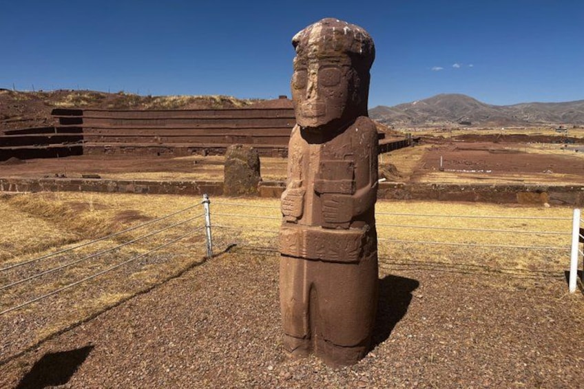 Una gran estatua de piedra en un paisaje árido y abierto, con montañas al fondo. 2