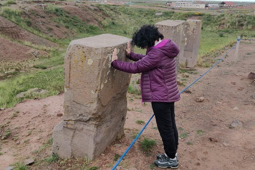 Una persona observa una gran estructura de piedra en un paisaje rural. 3