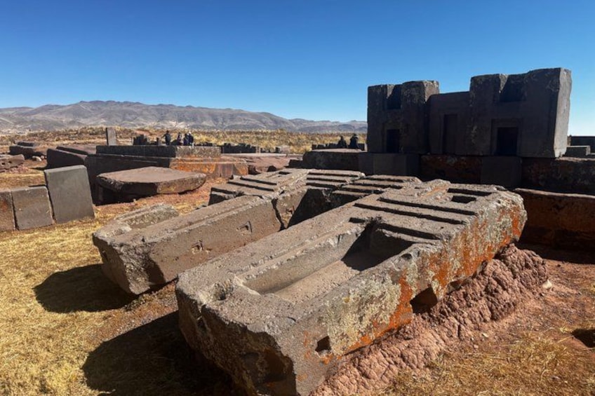 Ruinas antiguas con estructuras de piedra y un paisaje montañoso de fondo. 4