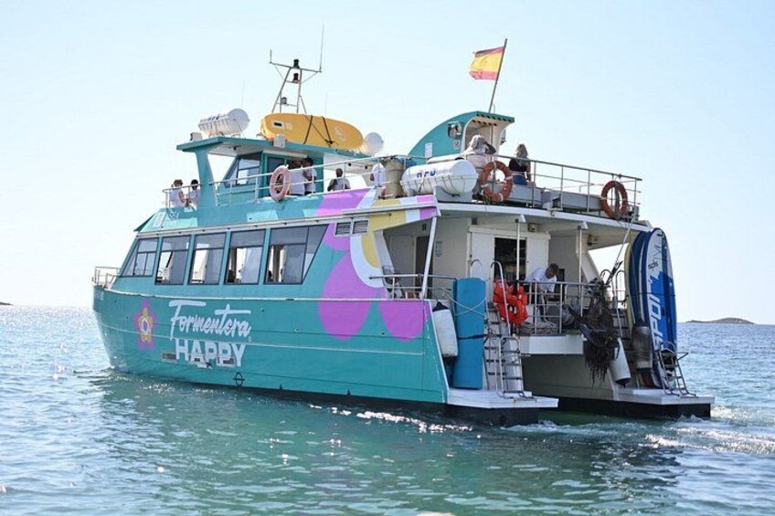Un barco turquesa con la inscripción 'Formentera Happy', navegando sobre el agua. 3