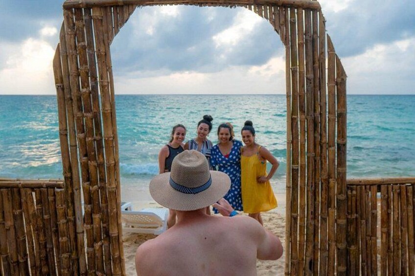 Eine Strandansicht mit einem Bambusbogen, dem Meer und Menschen. 5