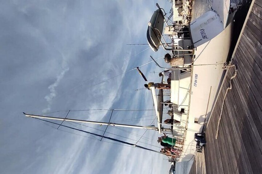 A sailboat docked at a pier with a cloudy sky in the background. 5