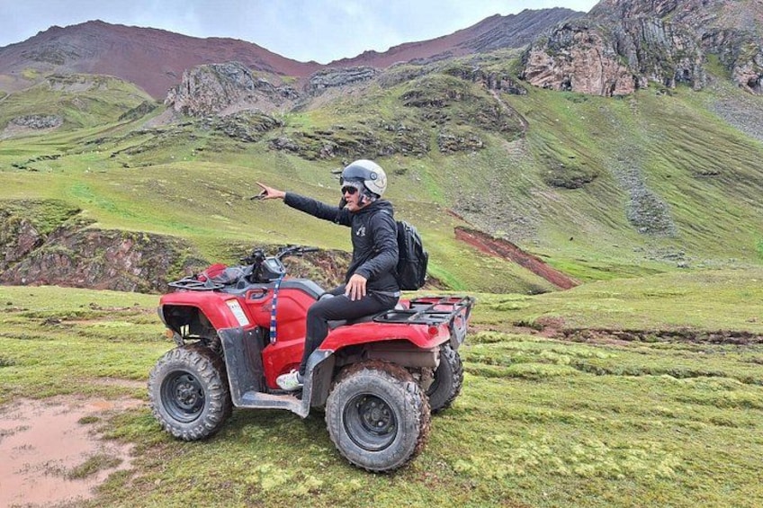 Iemand op een rode quadwijze die naar het landschap wijst. 4