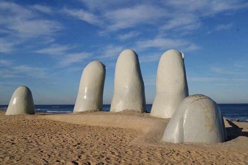 Una playa arenosa con cinco grandes estructuras blancas y lisas de hormigón. 2