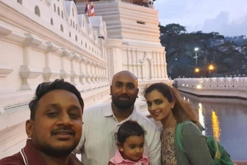 Una familia de cuatro personas frente a un templo blanco con un estanque reflectante. 1