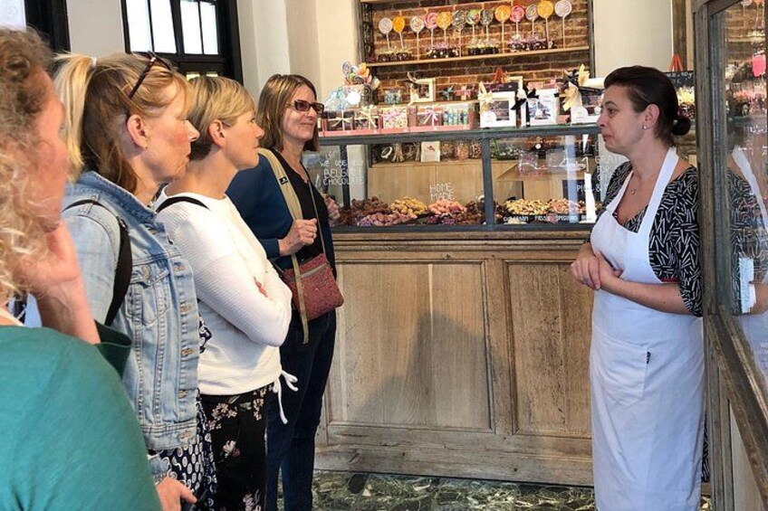 Un groupe de personnes se tient devant une vitrine où sont exposés divers articles. 2