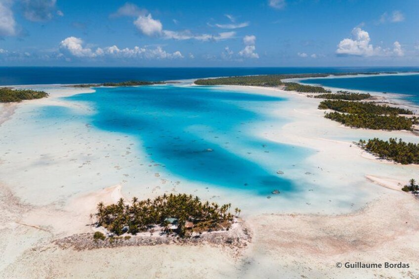 Una laguna turquesa rodeada de playas de arena blanca y pequeñas islas con vegetación exuberante. 1