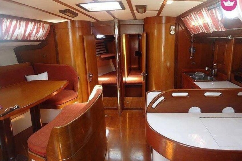 Interior de una cabaña con muebles de madera, una mesa de comedor y una zona de cocina. 2