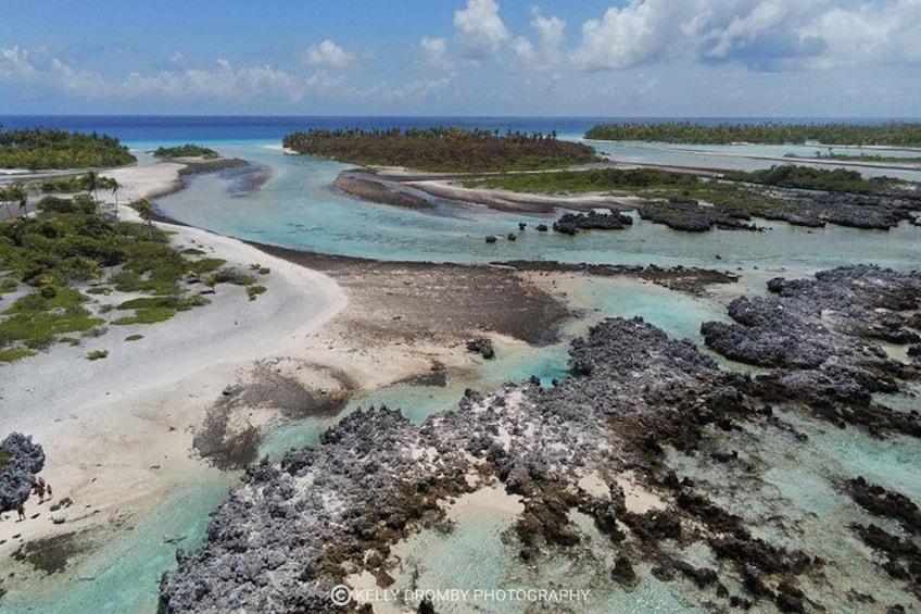 A coastal landscape with clear turquoise waters, sandy beaches, and rocky outcrops. 3