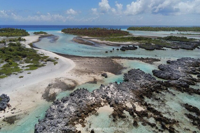A coastal landscape with clear turquoise waters, sandy beaches, and rocky outcrops. 1