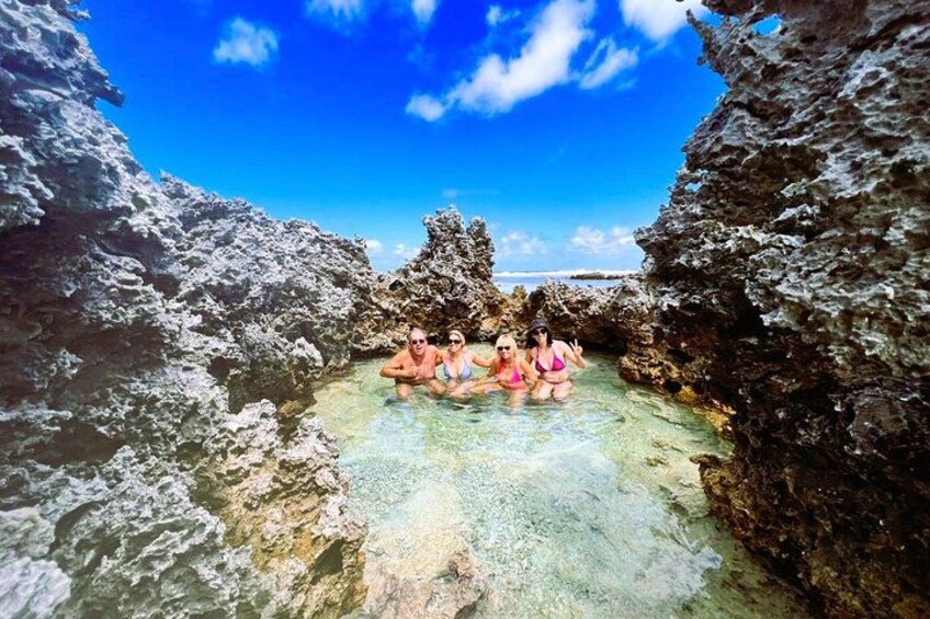 A group of people in a natural hot spring surrounded by rocky formations. 3