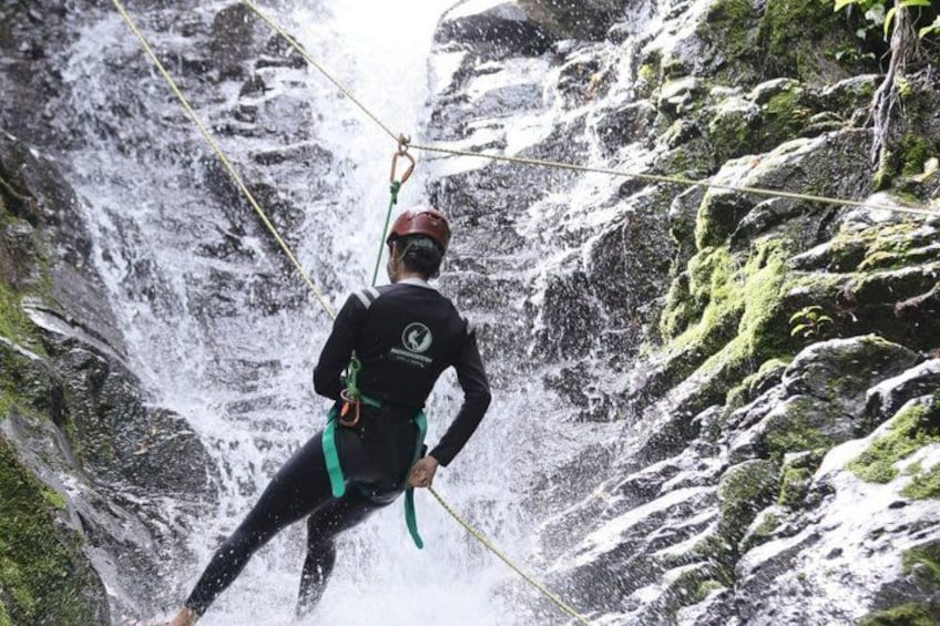 A person rappelling down a waterfall. 3