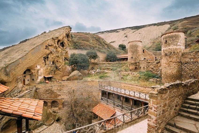 A historical site with ancient ruins, including a stone bridge and a castle-like structure. 3