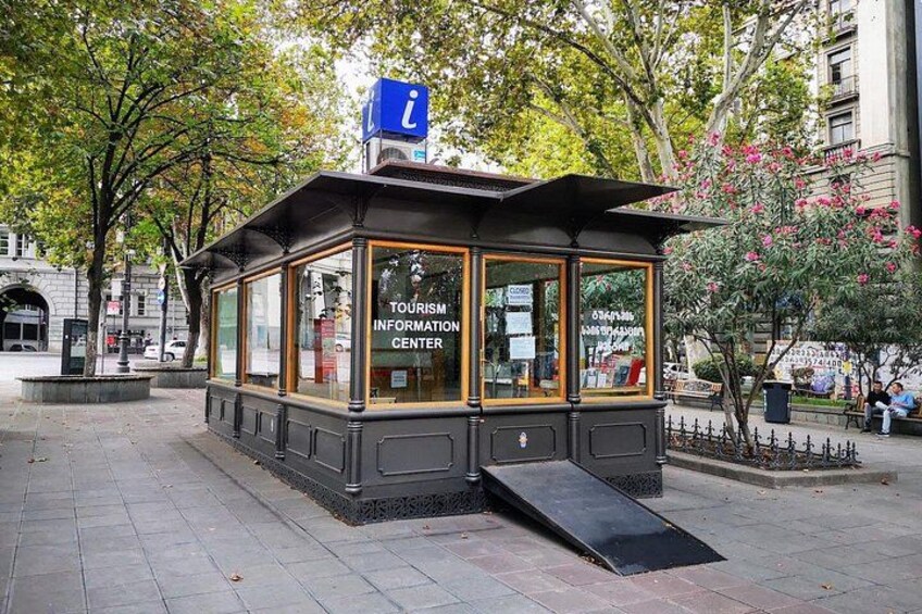 A Tourism Information Center with a blue sign, glass windows, and a ramp. 2
