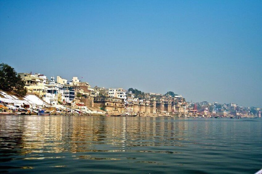 A riverside cityscape with historic buildings and a clear sky. 2