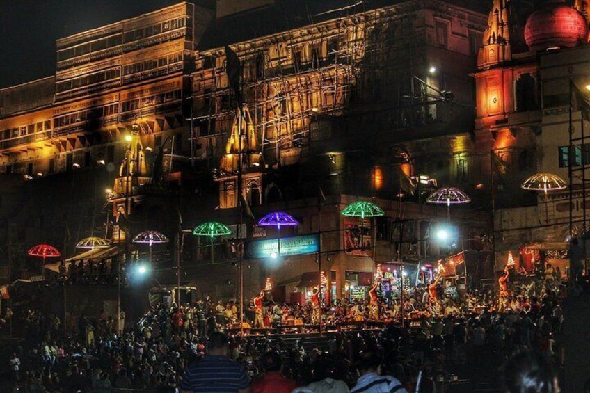 A crowded outdoor event with illuminated umbrellas and a large crowd. 3