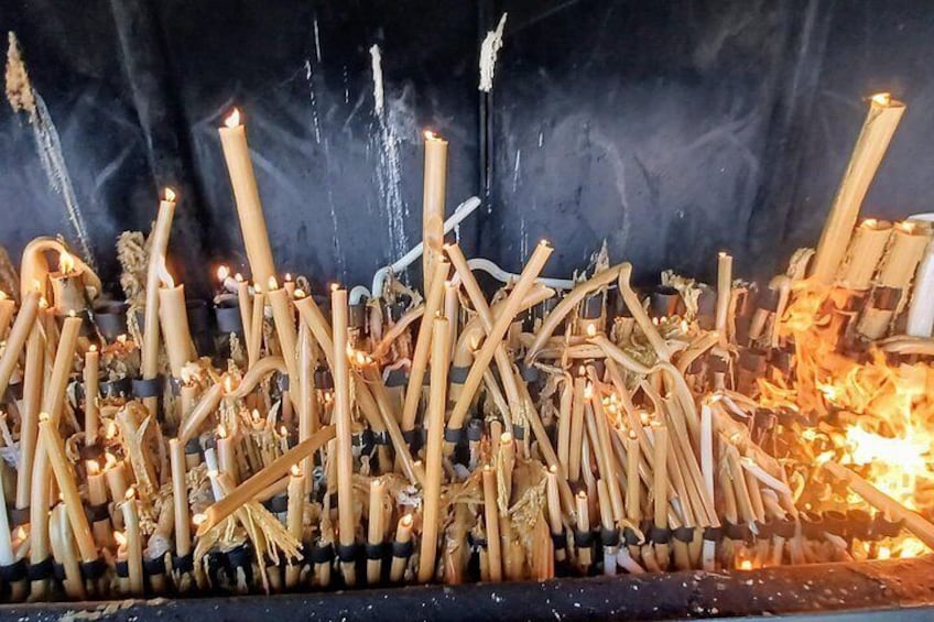 A large number of burning incense sticks in a dark setting. 5